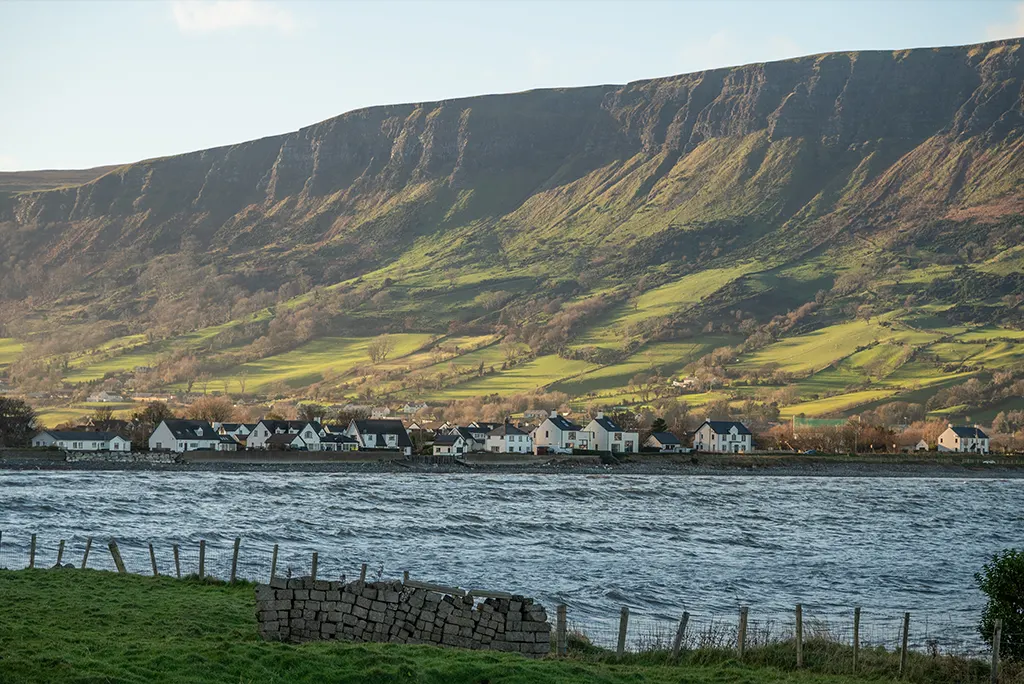 Paysage côtier avec falaises et petit village au bord de l’eau